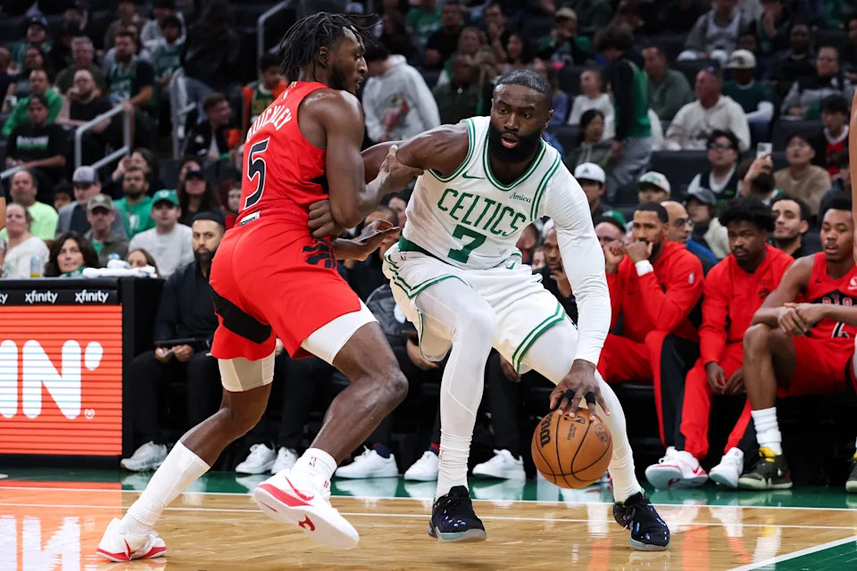 Oct 15, 2025; Boston, Massachusetts, USA; Boston Celtics forward Jaylen Brown (7) defended by Toronto Raptors guard Immanuel Quickley (5) during the first half at TD Garden. Mandatory Credit: Paul Rutherford-Imagn Images