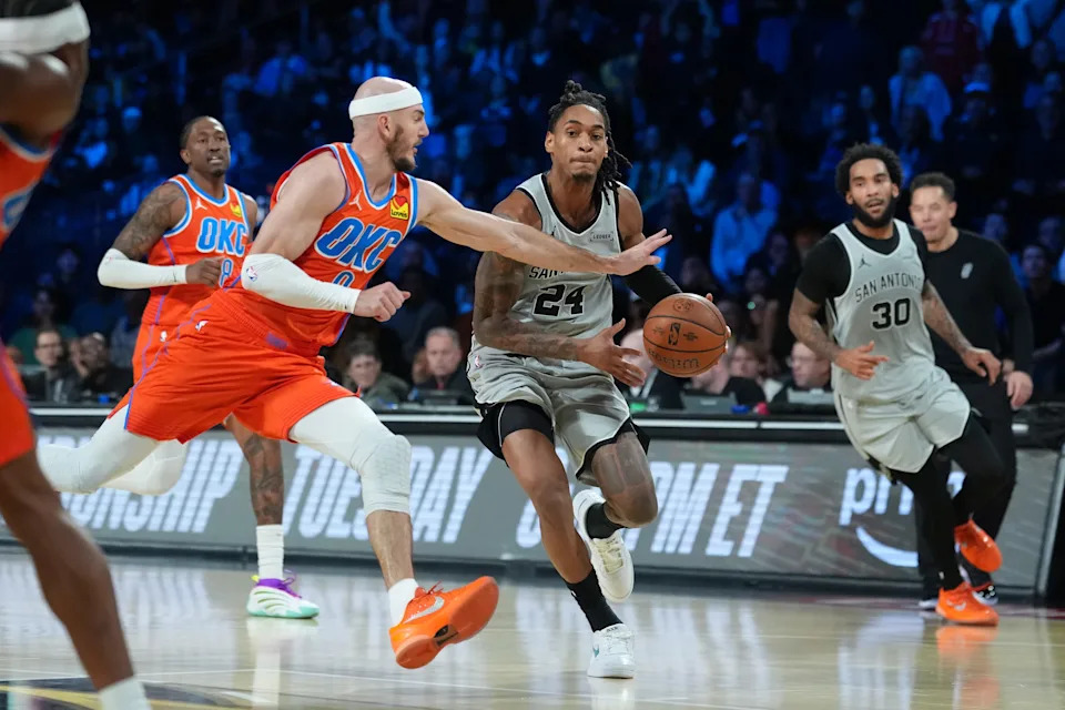 Dec 13, 2025; Las Vegas, Nevada, USA; San Antonio Spurs guard Devin Vassell (24) works past Oklahoma City Thunder guard Alex Caruso (9) during the fourth quarter at T-Mobile Arena. Mandatory Credit: Kirby Lee-Imagn Images