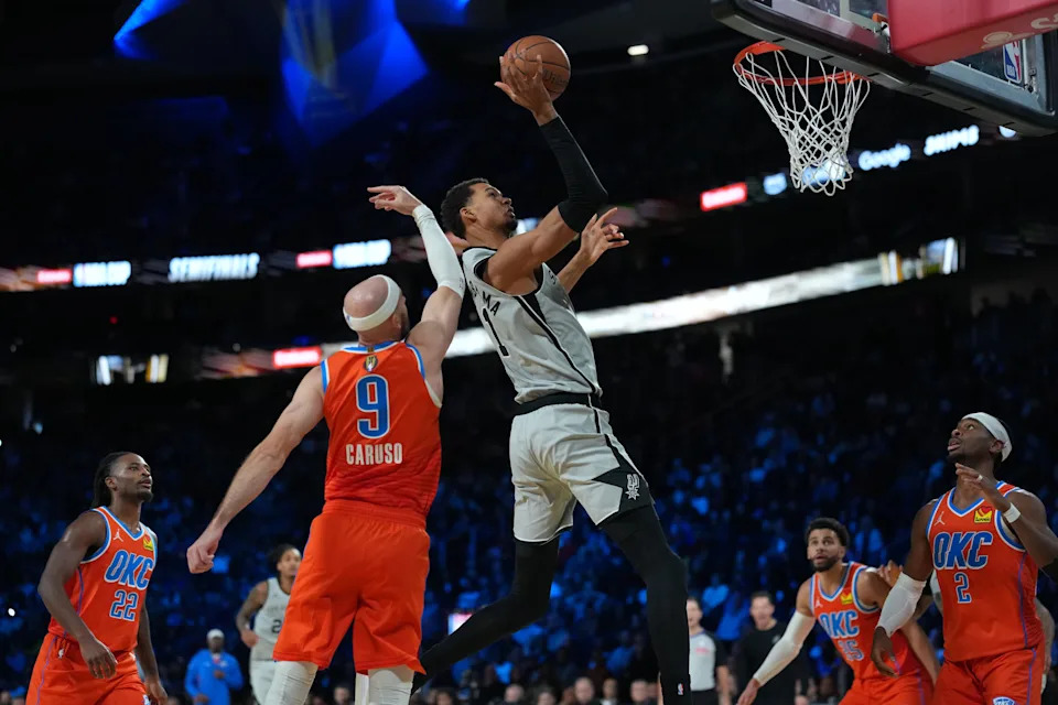 Dec 13, 2025; Las Vegas, Nevada, USA; San Antonio Spurs forward Victor Wembanyama (1) goes to the basket as Oklahoma City Thunder guard Alex Caruso (9) defends during the fourth quarter at T-Mobile Arena. Mandatory Credit: Kirby Lee-Imagn Images