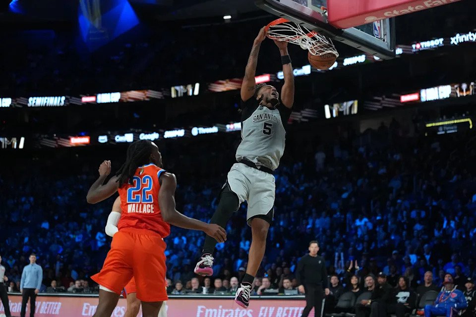 Dec 13, 2025; Las Vegas, Nevada, USA; San Antonio Spurs guard Stephon Castle (5) goes up for the dunk as Oklahoma City Thunder guard Cason Wallace (22) looks on during the fourth quarter at T-Mobile Arena. Mandatory Credit: Kirby Lee-Imagn Images