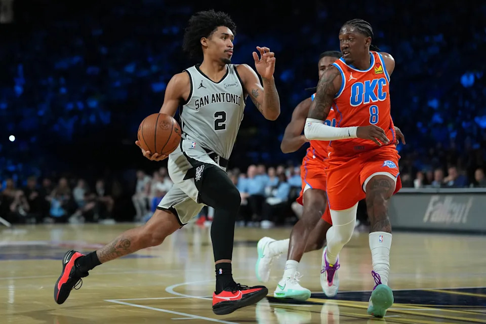 Dec 13, 2025; Las Vegas, Nevada, USA; San Antonio Spurs guard Dylan Harper (2) drives the lane on Oklahoma City Thunder guard Jalen Williams (8) during the third quarter at T-Mobile Arena. Mandatory Credit: Kirby Lee-Imagn Images