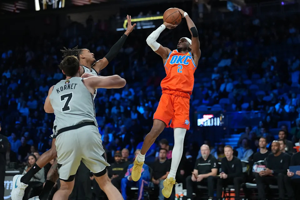 Dec 13, 2025; Las Vegas, Nevada, USA; Oklahoma City Thunder guard Shai Gilgeous-Alexander (2) shoots a jump shot over San Antonio Spurs guard Devin Vassell (24) during the first quarter at T-Mobile Arena. Mandatory Credit: Kirby Lee-Imagn Images
