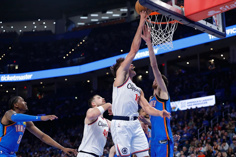 Dec 18, 2025; Oklahoma City, Oklahoma, USA; Los Angeles Clippers guard Bogdan Bogdanovic (10) goes up for a basket as Oklahoma City Thunder center Chet Holmgren (7) defends during the second half at Paycom Center. Mandatory Credit: Alonzo Adams-Imagn Images