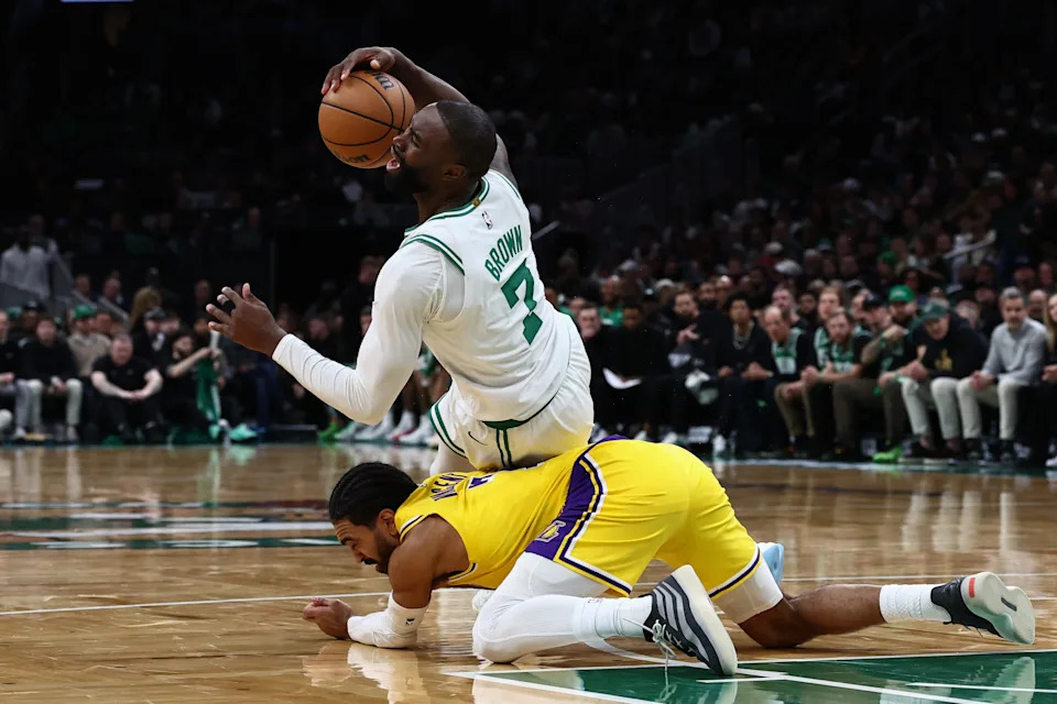 Dec 5, 2025; Boston, Massachusetts, USA; Boston Celtics guard Jaylen Brown (7) falls over Los Angeles Lakers guard Gabe Vincent (7) during the second half at TD Garden. Mandatory Credit: Winslow Townson-Imagn Images