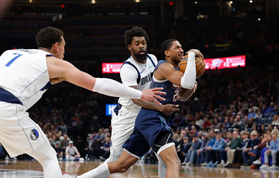Dec 5, 2025; Oklahoma City, Oklahoma, USAOklahoma City Thunder guard Aaron Wiggins (21) drives between Dallas Mavericks forward Dwight Powell (7) and forward Naji Marshall (13) during the second half at Paycom Center. Mandatory Credit: Alonzo Adams-Imagn Images