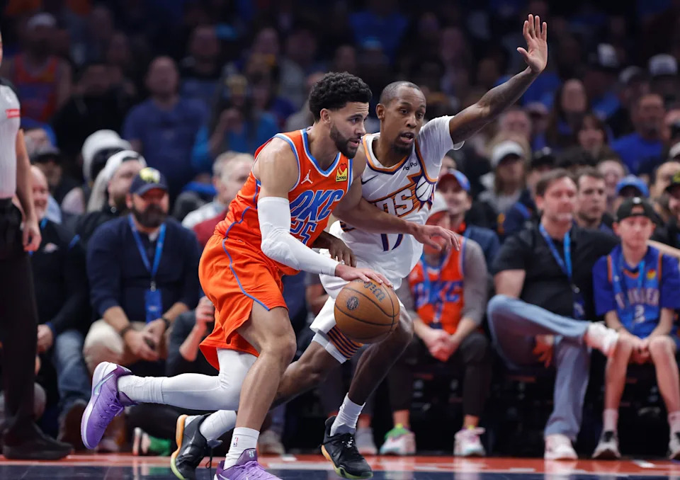 Dec 10, 2025; Oklahoma City, Oklahoma, USA; Oklahoma City Thunder guard Ajay Mitchell (25) drives beside Phoenix Suns guard Jamaree Bouyea (17) during the second quarter at Paycom Center. Mandatory Credit: Alonzo Adams-Imagn Images