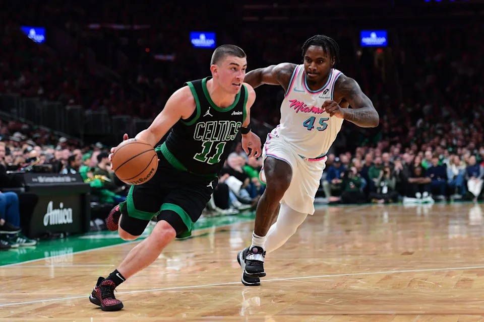 Apr 2, 2025; Boston, Massachusetts, USA; Boston Celtics guard Payton Pritchard (11) controls the ball while Miami Heat guard Davion Mitchell (45) defends during the second half at TD Garden. Mandatory Credit: Bob DeChiara-Imagn Images