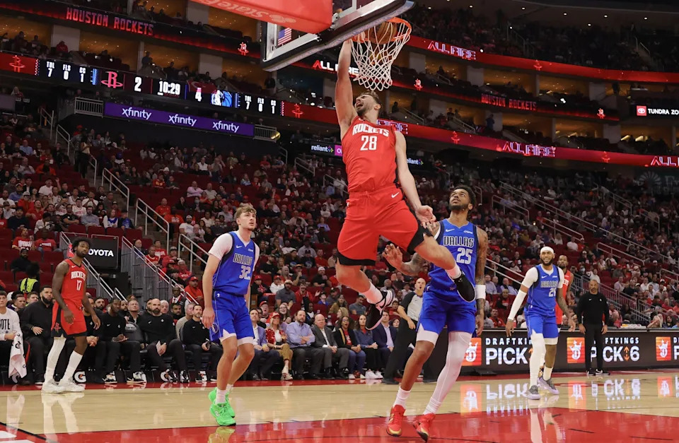 Nov 3, 2025; Houston, Texas, USA; Houston Rockets center Alperen Sengun (28) dunks against Dallas Mavericks forward P.J. Washington (25) in the first quarter at Toyota Center. Mandatory Credit: Thomas Shea-Imagn Images