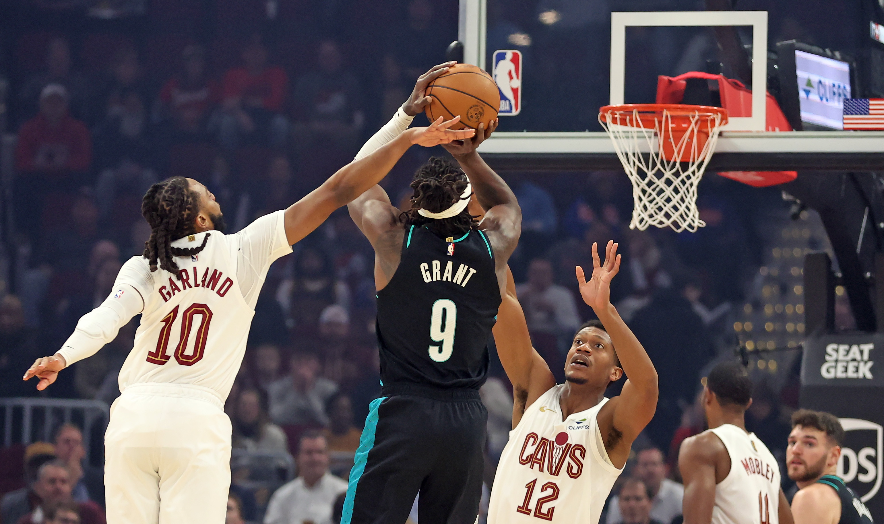 Cleveland Cavaliers guard Darius Garland tries to deflect a shot by Portland Trail Blazers forward Jerami Grant in the first half of play. 
