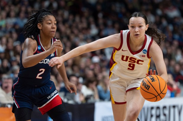 Southern California guard Kayleigh Heckel (9) drives the ball toward the basket as UConn guard KK Arnold (2) defends during the first half in the Elite Eight of the NCAA college basketball tournament Monday, March 31, 2025, in Spokane, Wash. (AP Photo/Jenny Kane)