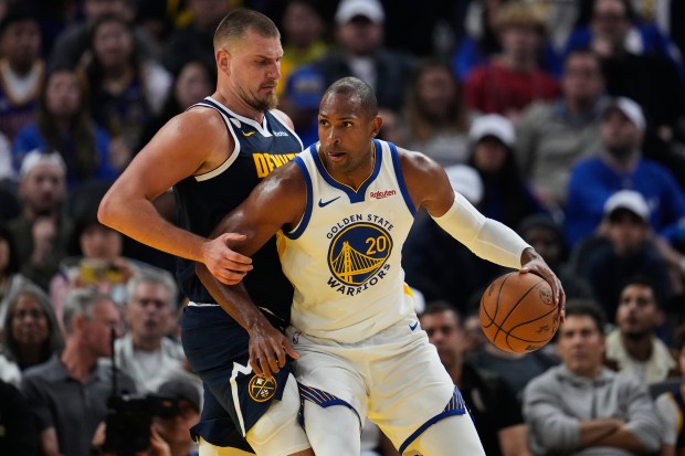 Golden State Warriors center Al Horford (20) looks for an open teammate while being defended by Denver Nuggets center Nikola Jokic (15) during the first half of an NBA basketball game, Thursday, Oct. 23, 2025, in San Francisco. (AP Photo/Godofredo A. Vásquez)