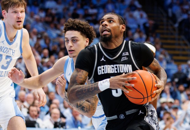 Georgetown's KJ Lewis, right, drives as North Carolina's Kyan Evans, second from right, defends during the second half of an NCAA college basketball game in Chapel Hill, N.C., Sunday, Dec. 7, 2025. (AP Photo/Ben McKeown)