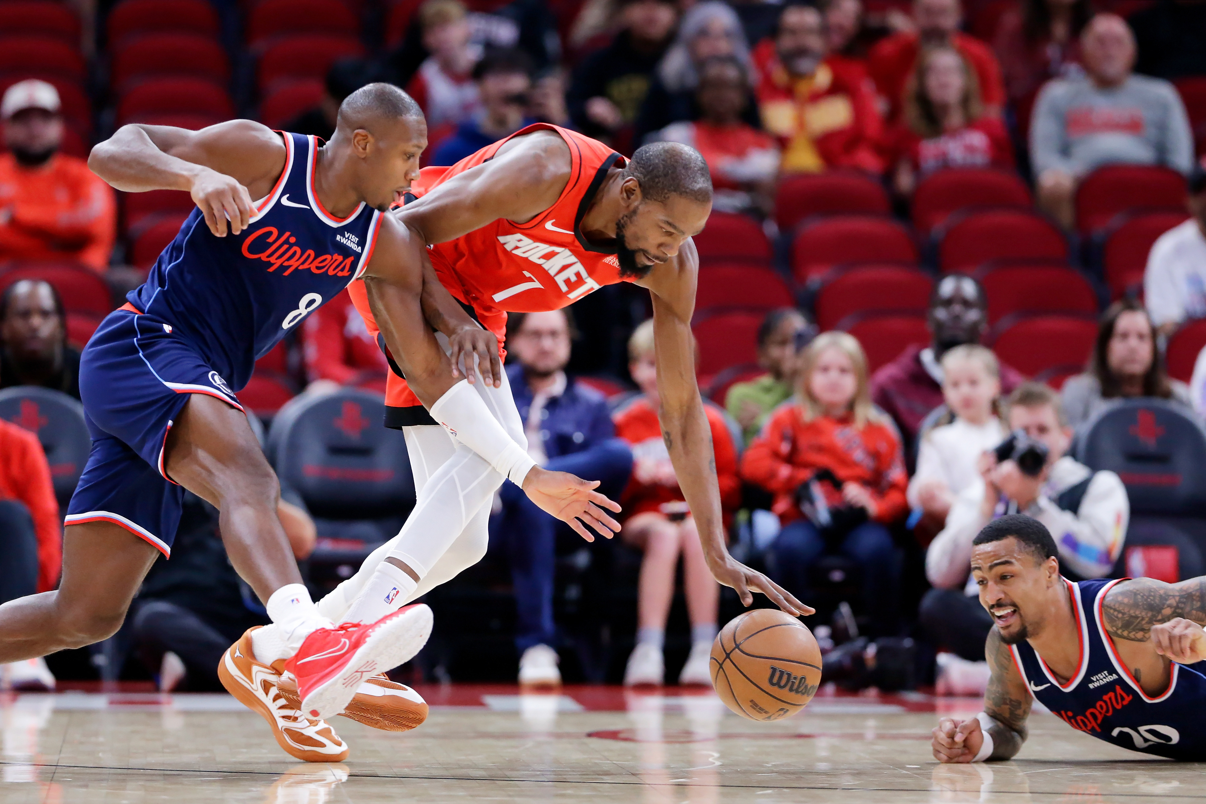 Houston Rockets forward Kevin Durant, center, recovers a loose ball...