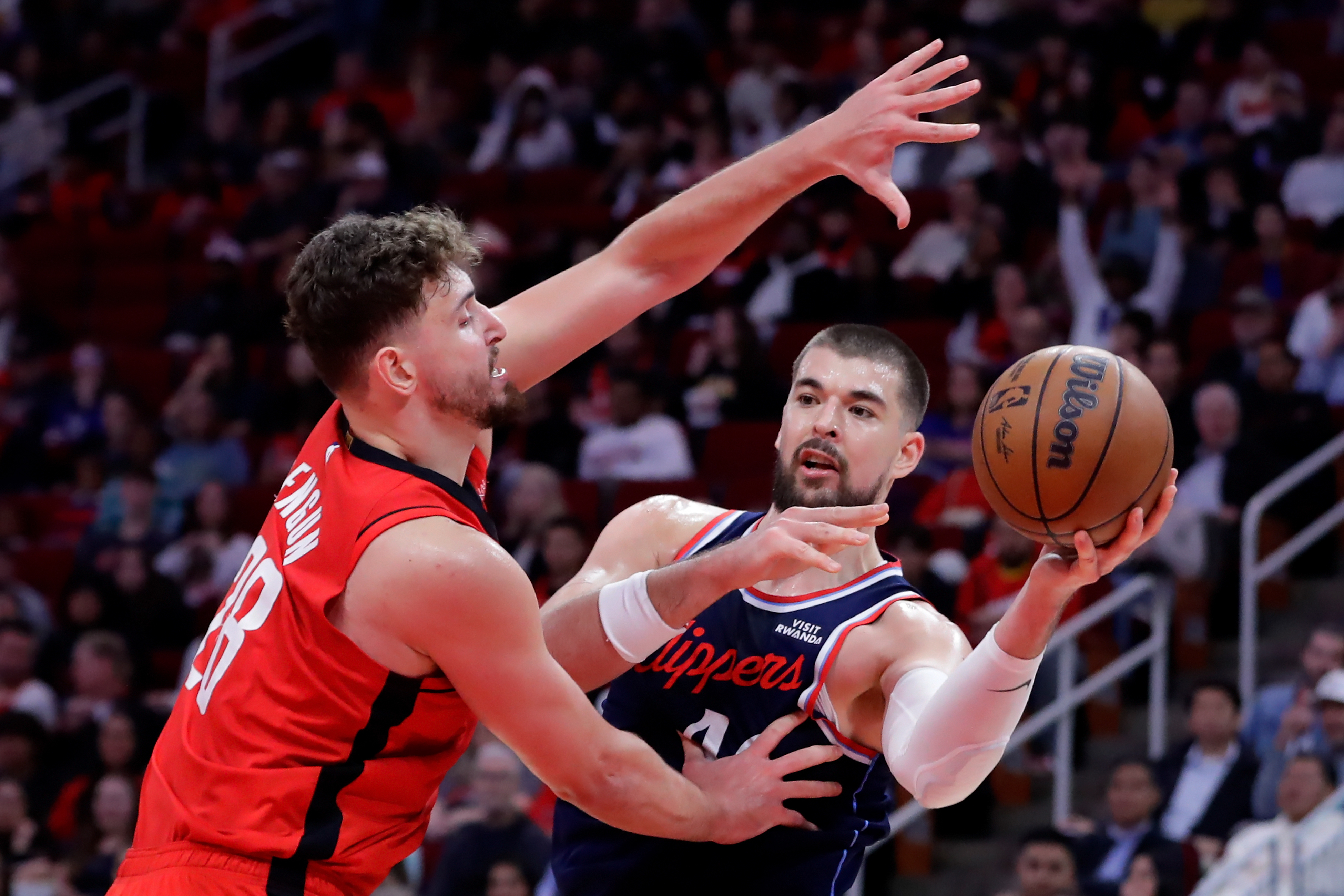 Clippers center Ivica Zubac, right, passes the ball while under...