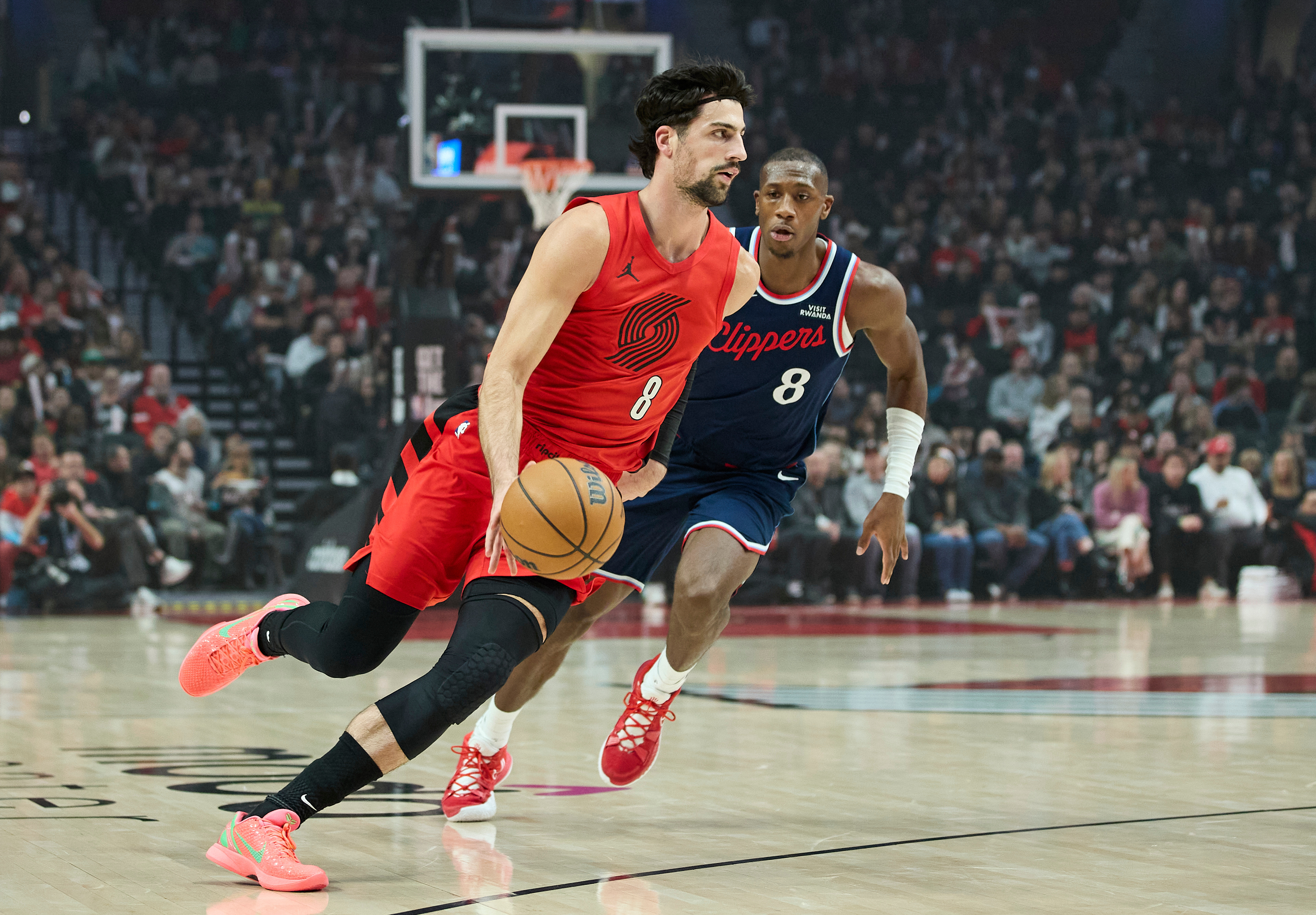 Portland Trail Blazers forward Deni Avdija, left, dribbles past Clippers...