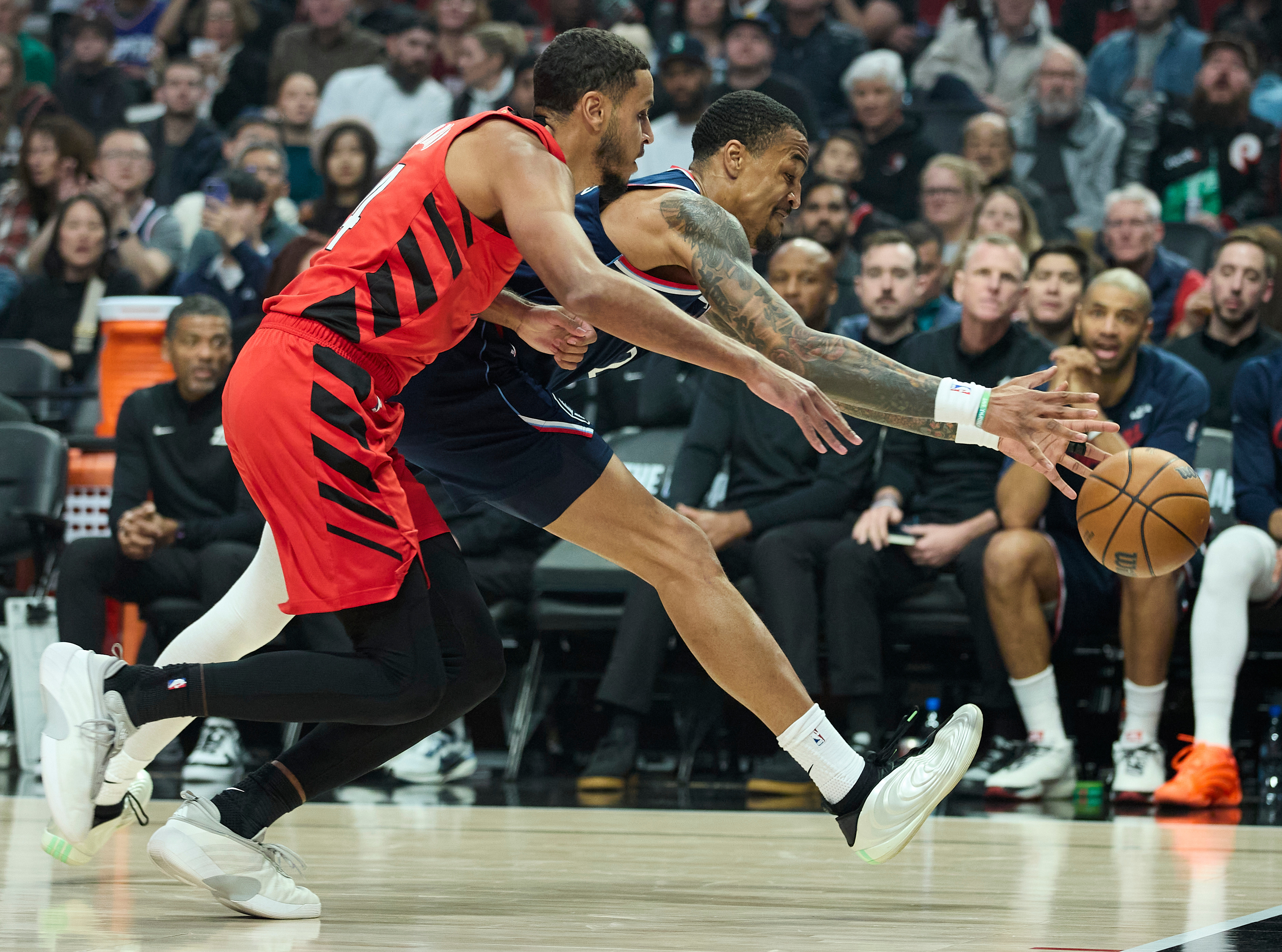 Clippers forward/center John Collins, right, reaches for a loose ball...