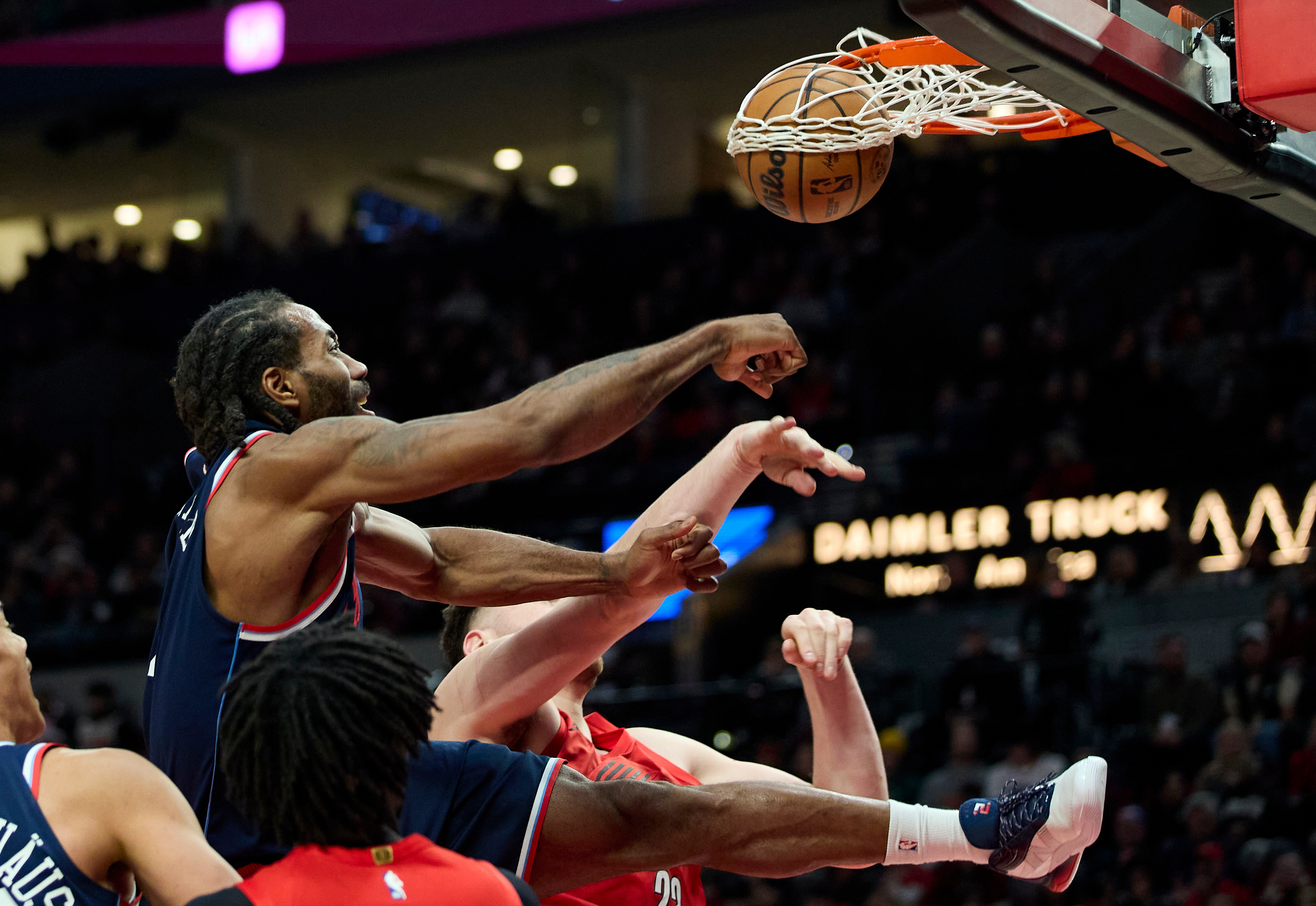 Clippers forward Kawhi Leonard, left, dunks over Portland Trail Blazers...