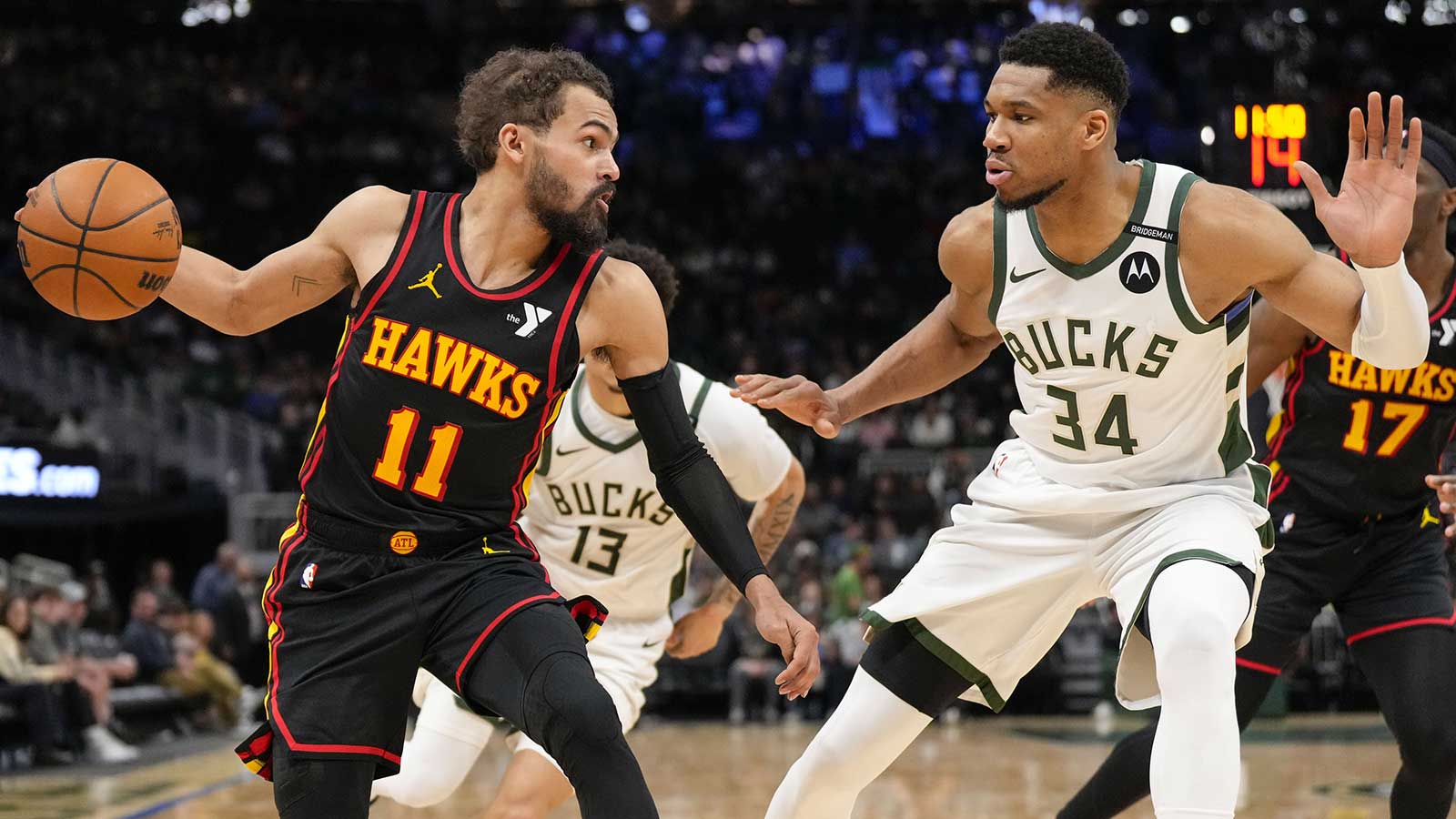 Atlanta Hawks guard Trae Young (11) dribbles the ball under pressure from Milwaukee Bucks forward Giannis Antetokounmpo (34) during the third quarter at Fiserv Forum.