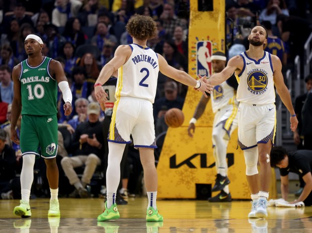 Golden State Warriors' Stephen Curry #30 and Brandin Podziemski #2 celebrate a basket in the first quarter of their NBA Christmas Day game against the Dallas Mavericks at the Chase Center in San Francisco, Calif., on Thursday, Dec. 25, 2025. (Jane Tyska/Bay Area News Group)