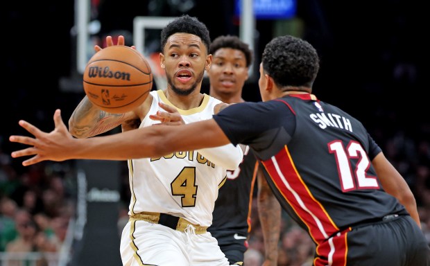 Boston Celtics guard Anfernee Simons (4) passes the ball past Miami Heat guard Dru Smith (12) during the second half of an NBA basketball game, Friday, Dec. 19, 2025, in Boston. (Mark Stockwell/Boston Herald)