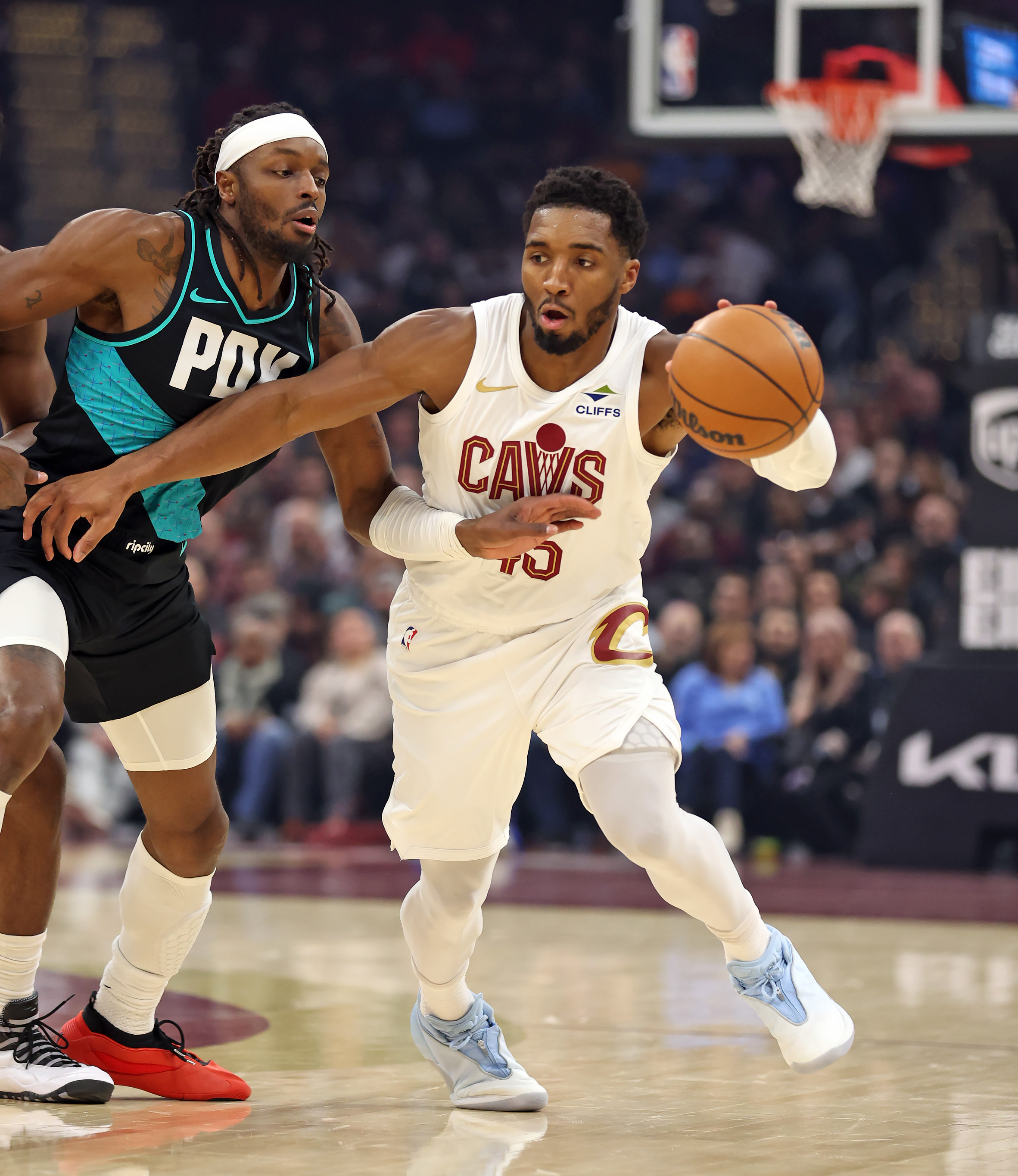 Cleveland Cavaliers guard Donovan Mitchell drives against Portland Trail Blazers forward Jerami Grant in the first half of play. 