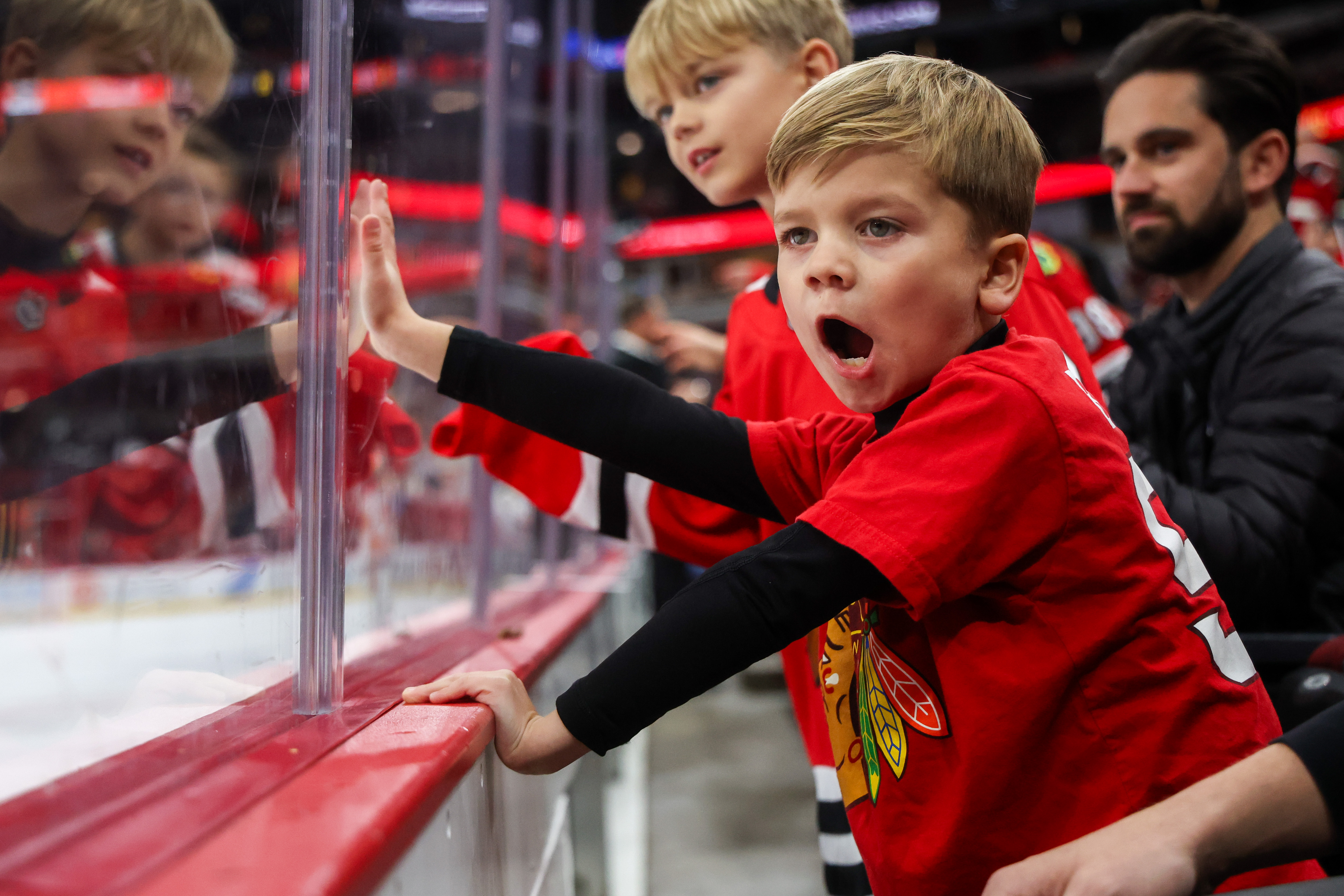 Jett Foster, 6, middle, yells to get the attention of...