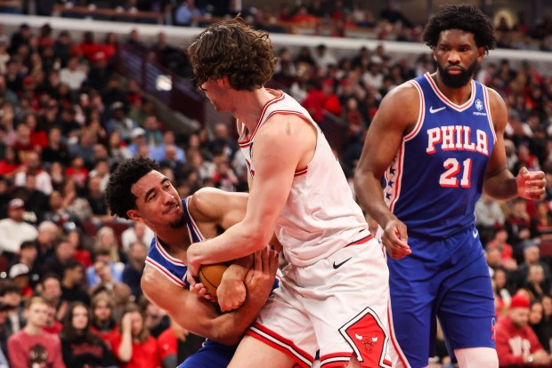 Chicago Bulls guard Josh Giddey (3) and Philadelphia 76ers forward Jabari Walker (33) wrestle for the ball in the second quarter, Friday, Dec. 26, 2025, at the United Center in Chicago. (Dominic Di Palermo/Chicago Tribune)