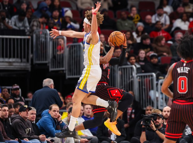 Chicago Bulls guard Jevon Carter (5) throws a pass while Golden State Warriors guard Brandin Podziemski (2) tries to block it in the first quarter during a game against the Golden State Warriors, Sunday, Dec. 7, 2025, at the United Center in Chicago. (Dominic Di Palermo/Chicago Tribune)