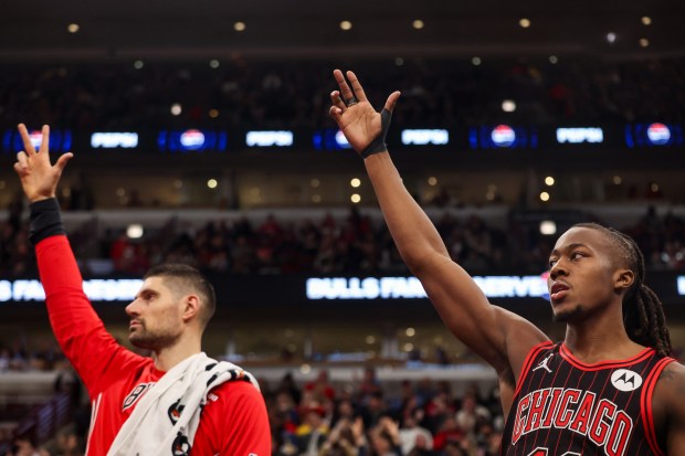 Chicago Bulls guard Ayo Dosunmu (11), right, and Chicago Bulls center Nikola Vučević (9) celebrate Chicago Bulls guard Josh Giddey's three-pointer in the third quarter during a game against the Golden State Warriors, Sunday, Dec. 7, 2025, at the United Center in Chicago. (Dominic Di Palermo/Chicago Tribune)