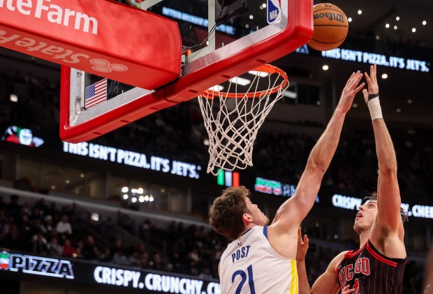 Chicago Bulls forward/center Zach Collins (12) goes up for a layup contested by Golden State Warriors center Quinten Post (21) in the fourth quarter, Sunday, Dec. 7, 2025, at the United Center in Chicago. (Dominic Di Palermo/Chicago Tribune)