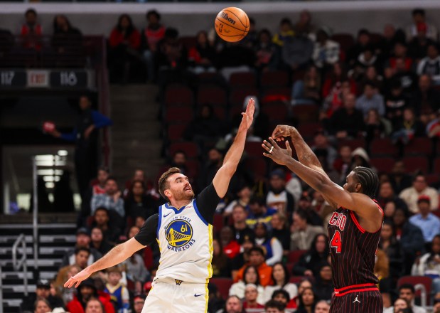 Chicago Bulls forward Patrick Williams (44) makes a three-pointer in the second quarter while Golden State Warriors guard Pat Spencer (61) attempts a block during a game, Sunday, Dec. 7, 2025, at the United Center in Chicago. (Dominic Di Palermo/Chicago Tribune)