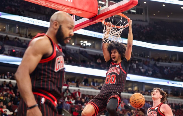 Chicago Bulls forward Trentyn Flowers (00) celebrates an alley-oop that was assisted by Chicago Bulls guard Jevon Carter (5) in the fourth quarter during a game against the Golden State Warriors, Sunday, Dec. 7, 2025, at the United Center in Chicago. (Dominic Di Palermo/Chicago Tribune)