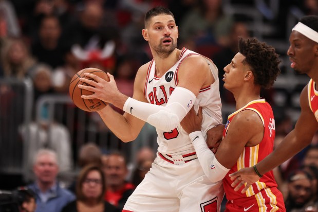 Bulls center Nikola Vučević keeps the ball away from Hawks forward Jalen Johnson on Oct. 27, 2025, at the United Center. (Dominic Di Palermo/Chicago Tribune)