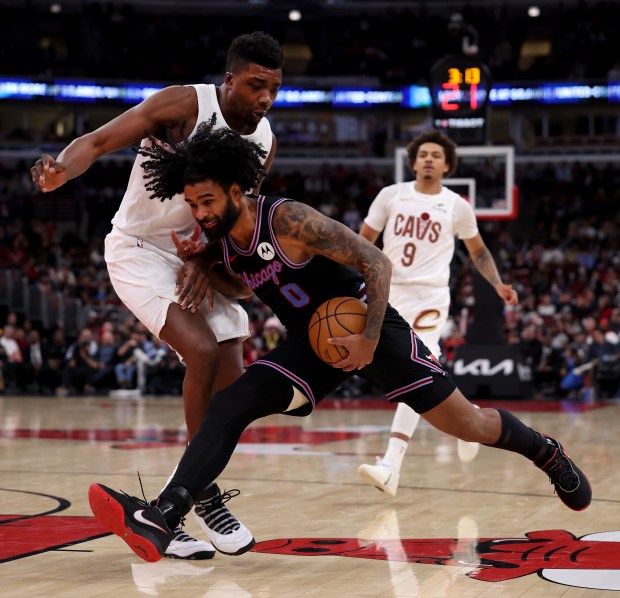 Chicago Bulls guard Coby White (0) drives on Cleveland Cavaliers center/forward Thomas Bryant (3) in the second half of a game at the United Center in Chicago on Dec. 17, 2025. (Chris Sweda/Chicago Tribune)