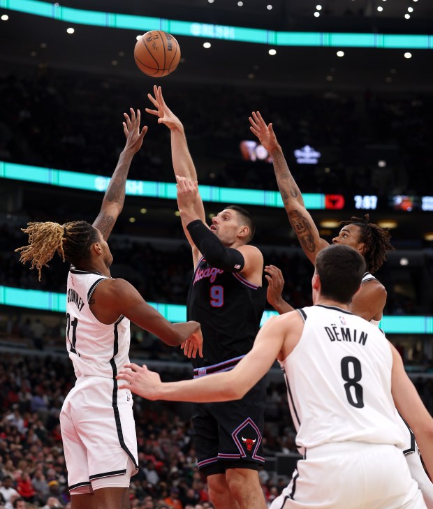 Chicago Bulls center Nikola Vučević (9) puts up a shot as Brooklyn Nets players defend on the play in the first half of a game at the United Center in Chicago on Dec. 3, 2025. (Chris Sweda/Chicago Tribune)