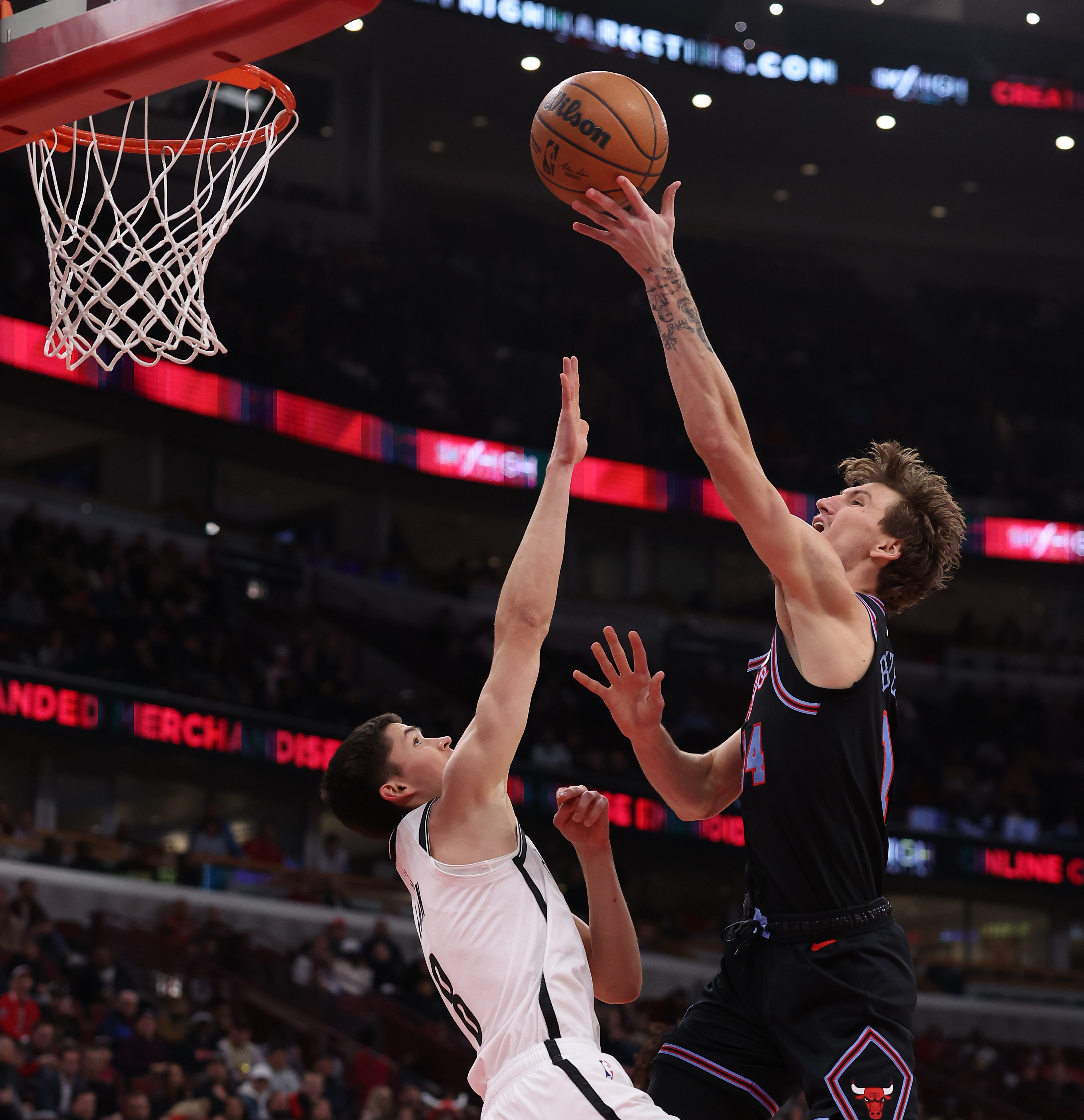 Chicago Bulls forward Matas Buzelis (14) scores over Brooklyn Nets guard Egor Dëmin (8) in the first half of a game at the United Center in Chicago on Dec. 3, 2025. (Chris Sweda/Chicago Tribune)