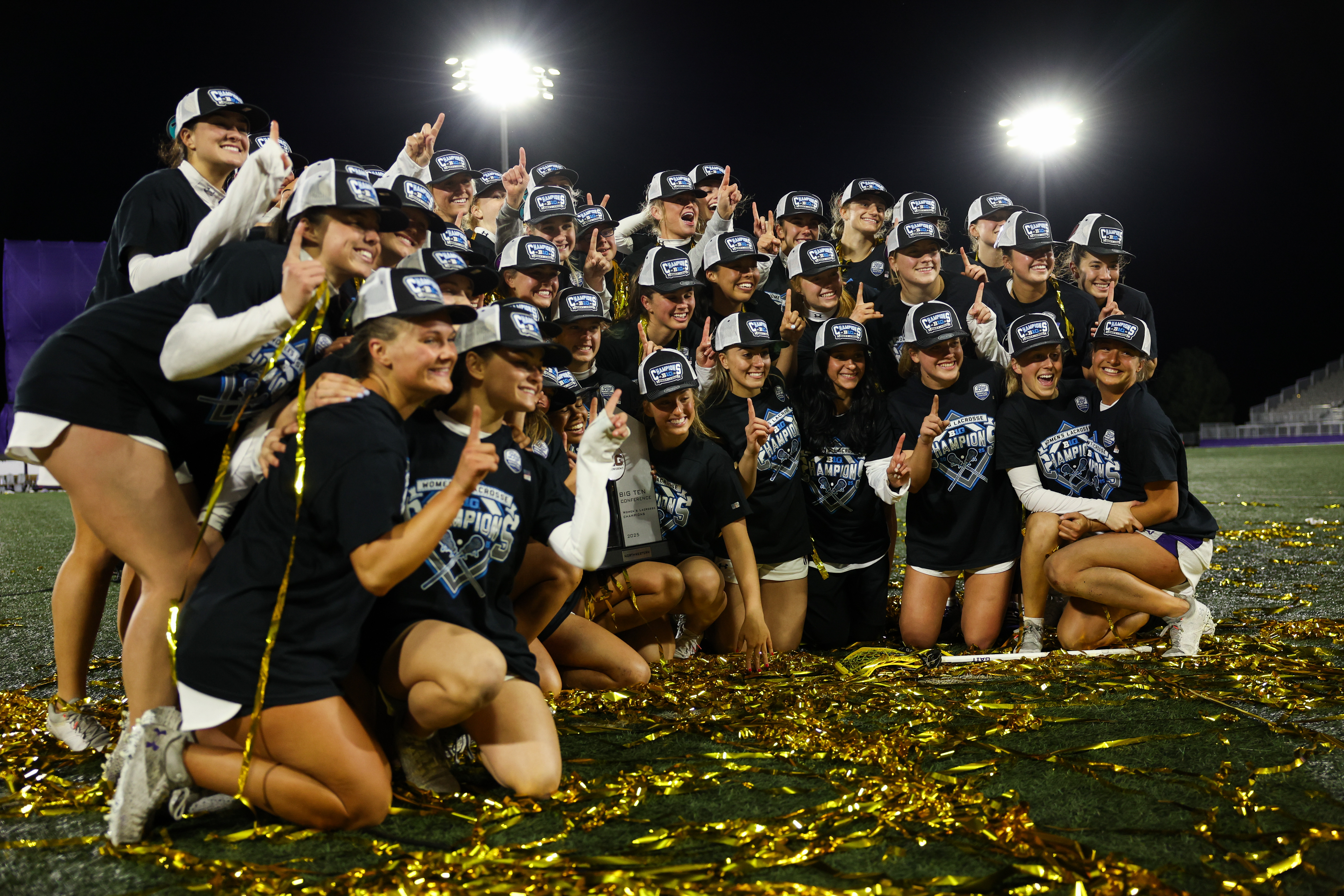 Northwestern players celebrate after defeating Michigan 15-6 to win the...