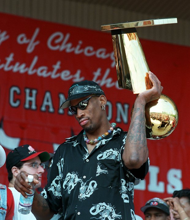 Dennis Rodman leaves the stage carrying on up-side-down NBA trophy at the Bulls' championship rally at Grant Park on June 16, 1998. (Chuck Berman/Chicago Tribune)