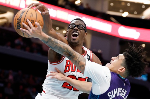 Bulls forward Jalen Smith, left, blocks the shot of Hornets guard KJ Simpson during the second half Friday, Dec. 12, 2025, in Charlotte, N.C. (Nell Redmond/AP)