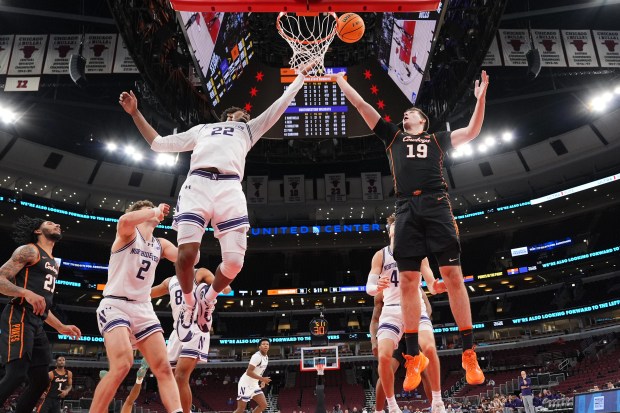 Oklahoma State's Andrija Vukovic battles for a rebound against Northwestern's Arrinten Page during the second half in the Thanksgiving Classic on Nov. 27, 2025, at the United Center. (AP Photo/Nam Y. Huh)
