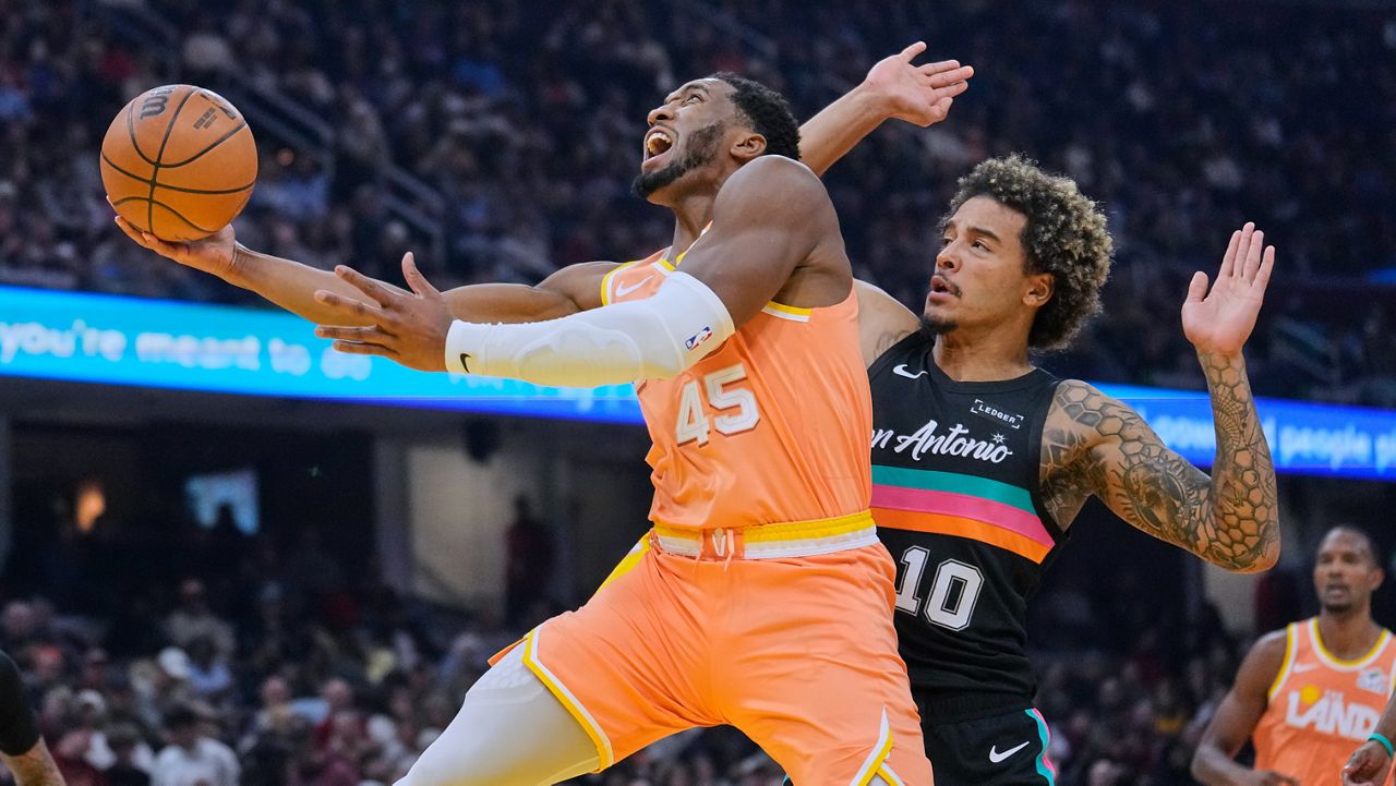 Cleveland Cavaliers guard Donovan Mitchell (45) drives to the basket past San Antonio Spurs forward Jeremy Sochan (10) in the first half of an NBA basketball game Friday, Dec. 5, 2025, in Cleveland.