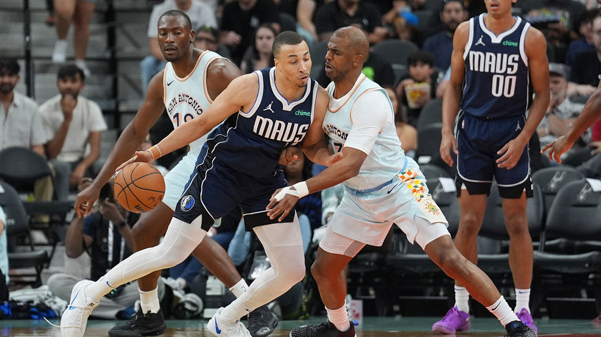 Dallas Mavericks guard Dante Exum (0) dribbles against San Antonio Spurs guard Chris Paul (3) in the first half at Frost Bank Center. 