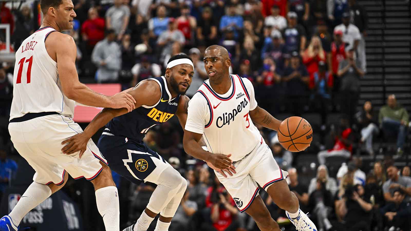 Los Angeles Clippers guard Chris Paul (3) moves the ball with center Brook Lopez (11) against Denver Nuggets guard Bruce Brown (11) during the second quarter at Intuit Dome. 