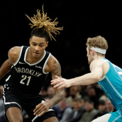 Brooklyn Nets forward Noah Clowney (21) drives past Charlotte Hornets guard Liam McNeeley during the first half of an NBA basketball game, Monday, Dec. 1, 2025, in New York. (AP Photo/Adam Hunger)