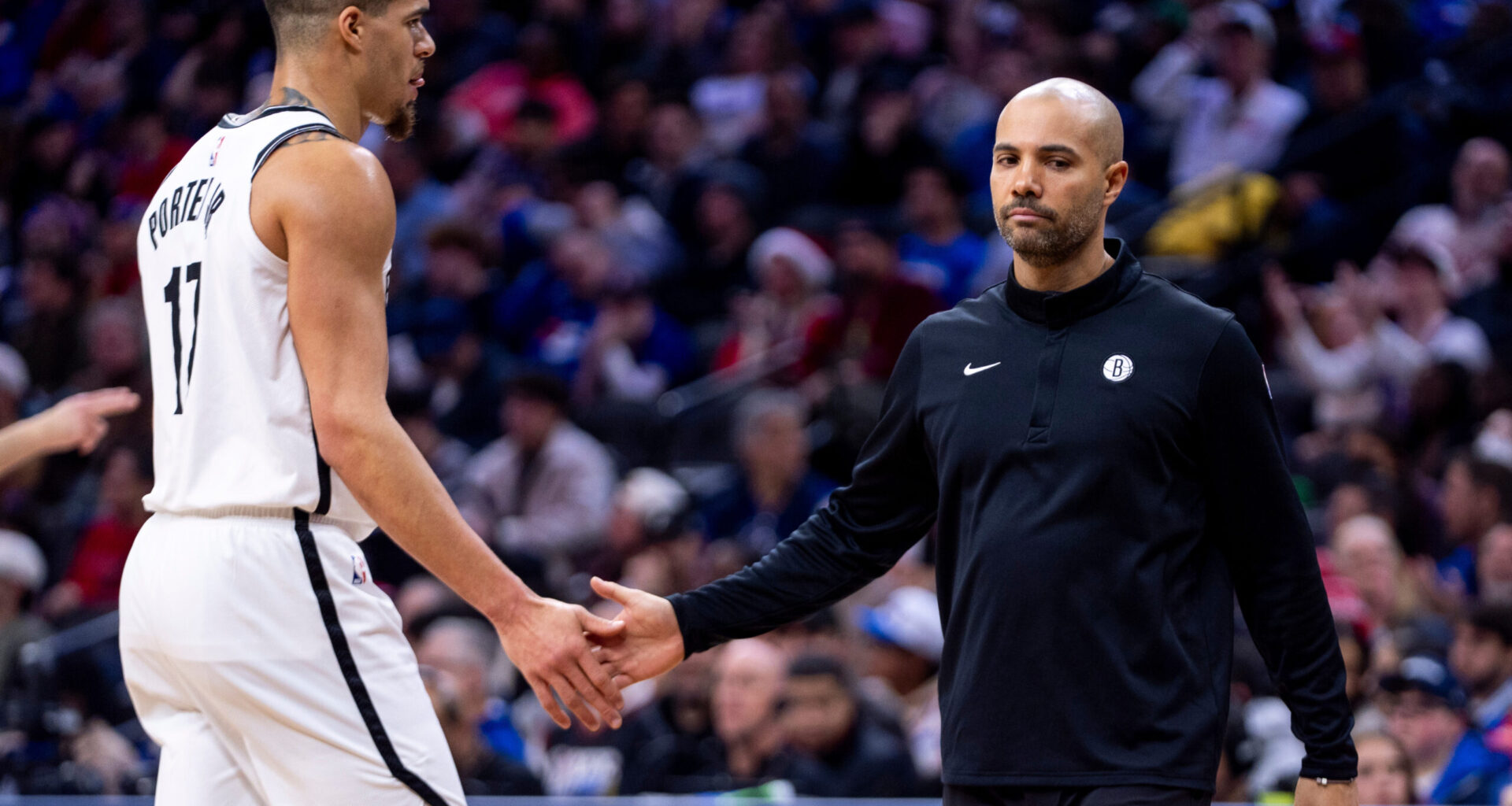Brooklyn Nets head coach Jordi Fernandez, right, low fives Michael Porter Jr., left, after time is called during the second half of an NBA basketball game against the Philadelphia 76ers, Tuesday, Dec. 23, 2025, in Philadelphia. (AP Photo/Chris Szagola)