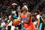 Oklahoma City Thunder guard Shai Gilgeous-Alexander, right, looks to the basket ahead of Portland Trail Blazers center Robert Williams III (35) during the second half of an NBA basketball game, Sunday, Nov. 30, 2025, in Portland, Ore. (AP Photo/Amanda Loman)