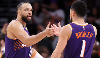 Dillon Brooks #3 of the Phoenix Suns high-fives teammate Devin Booker #1 after Brooks hit a three-p...
