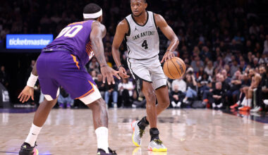 PHOENIX, ARIZONA - NOVEMBER 23: De'Aaron Fox #4 of the San Antonio Spurs dribbles the ball against Royce O'Neale #00 of the Phoenix Suns during the first half at Mortgage Matchup Center on November 23, 2025 in Phoenix, Arizona. The Suns defeated the Spurs 111-102. NOTE TO USER: User expressly acknowledges and agrees that, by downloading and or using this photograph, User is consenting to the terms and conditions of the Getty Images License Agreement. (Photo by Chris Coduto/Getty Images)