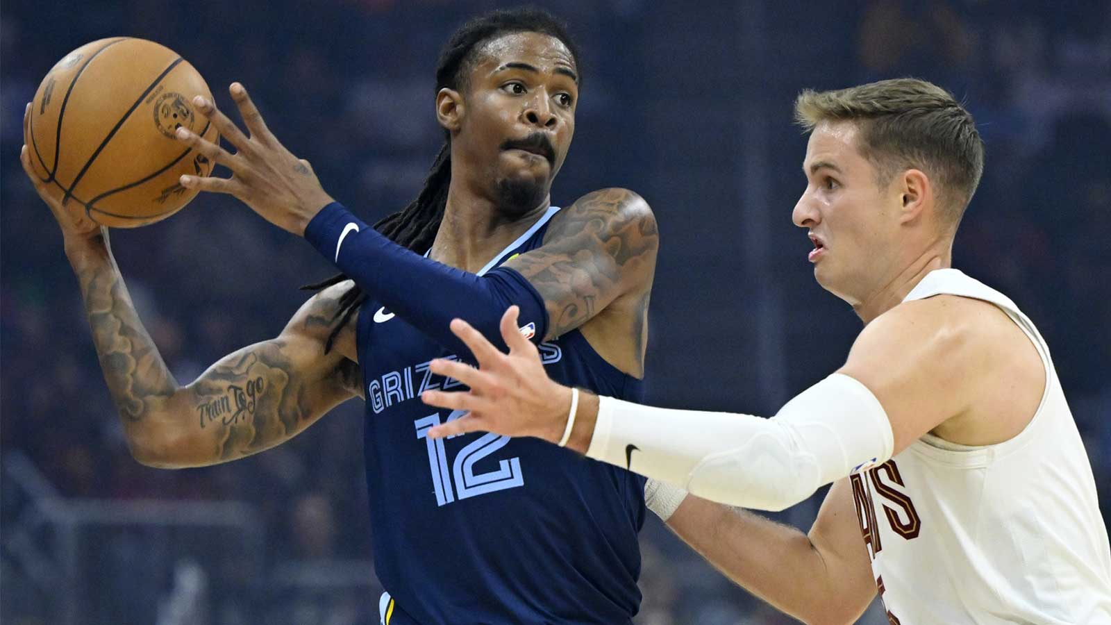 Memphis Grizzlies guard Ja Morant (12) looks to pass beside Cleveland Cavaliers guard Sam Merrill (5) in the first quarter at Rocket Arena.