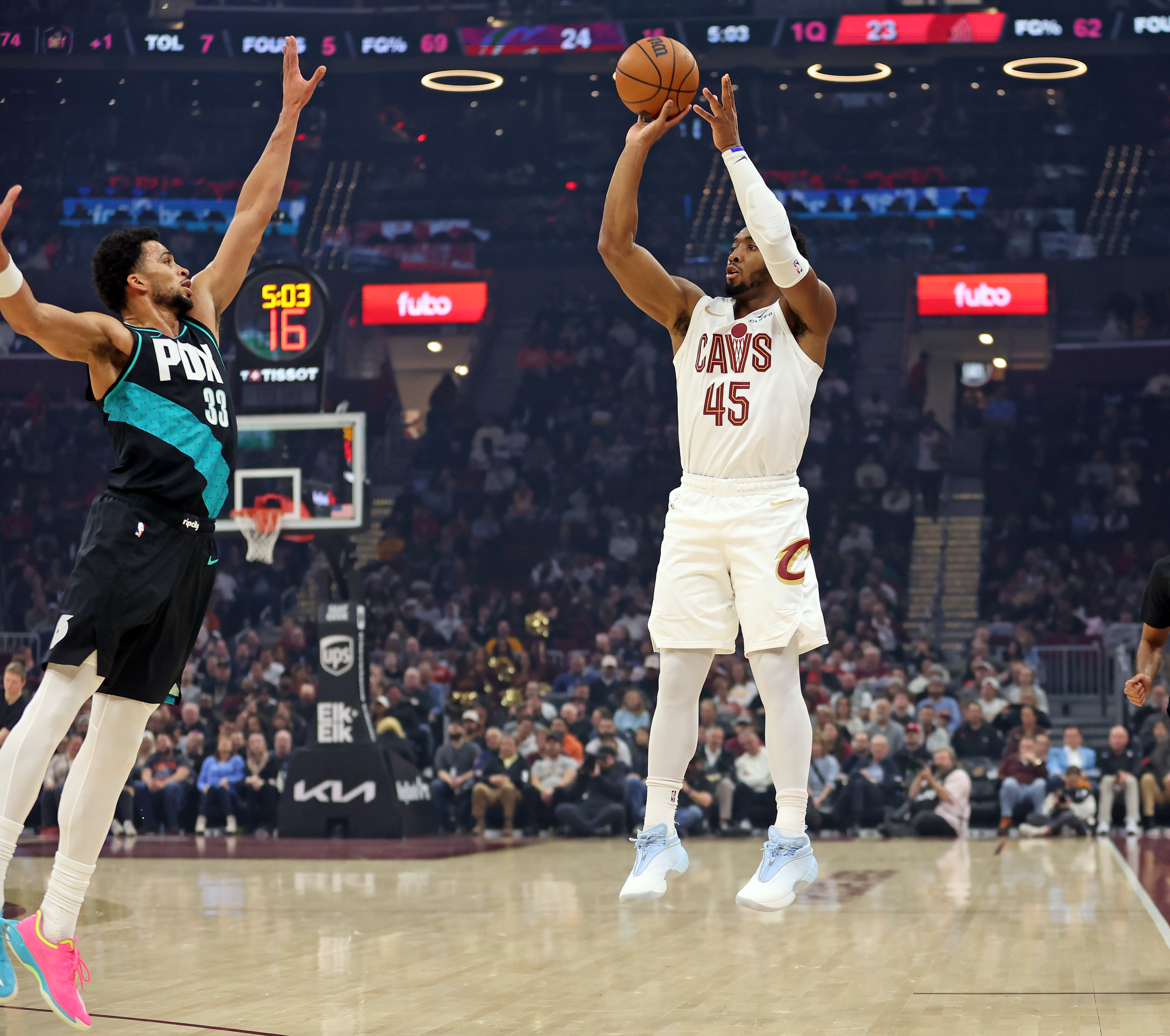 Cleveland Cavaliers guard Donovan Mitchell fires a three over Portland Trail Blazers forward Toumani Camara in the first half of play. 